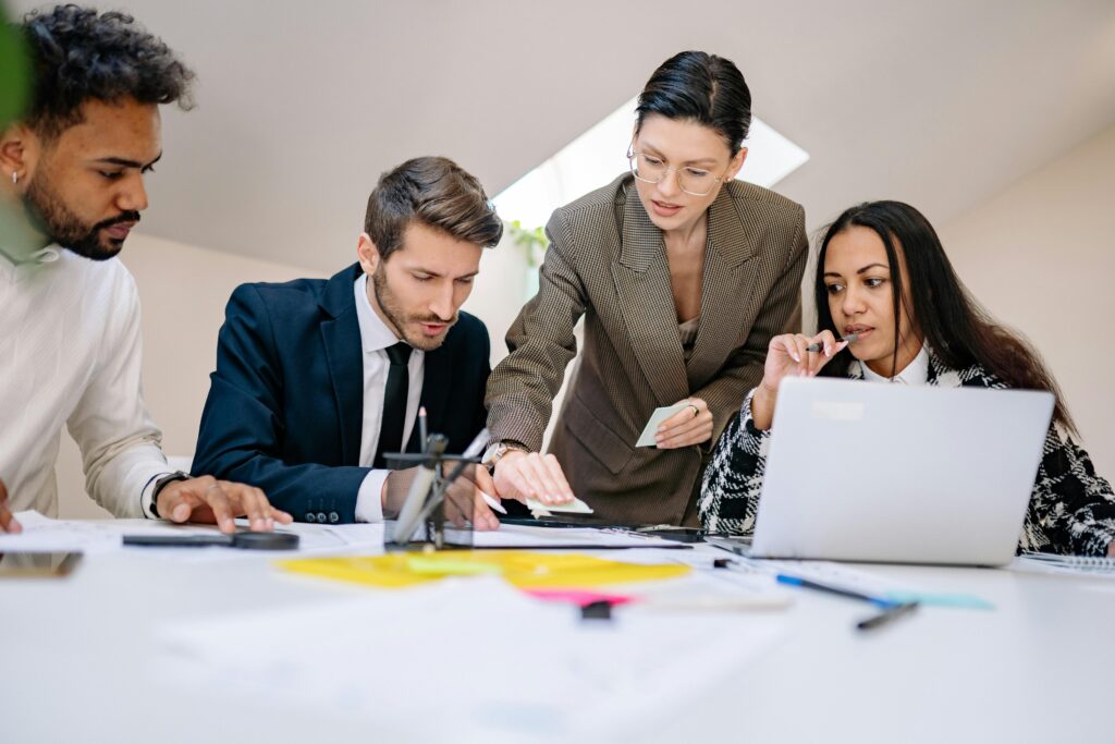 Business team working together at desk with documents and laptop in a contemporary office.